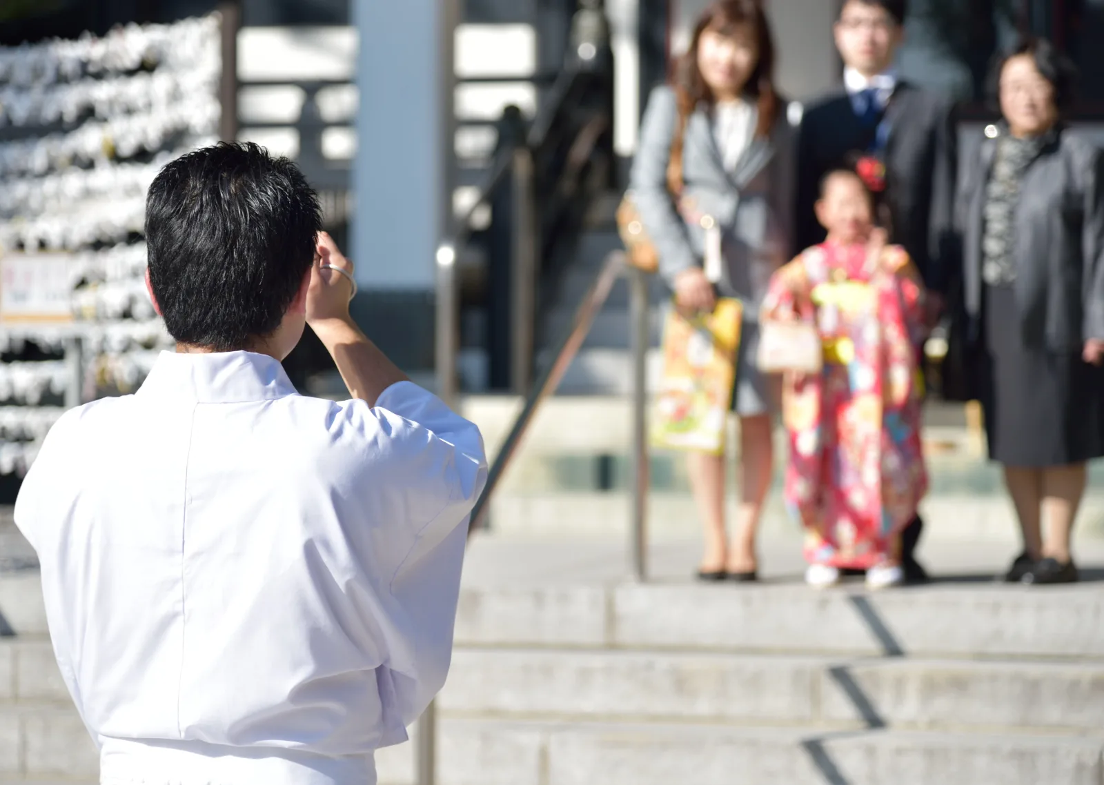神職がご家族の記念撮影をお手伝いする様子